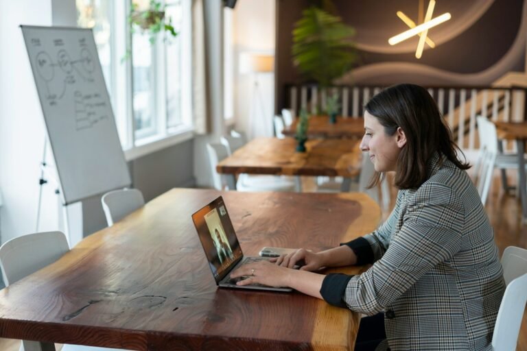 Onboarding und Weiterbildung im E-Commerce: So baust du ein starkes digitales Team auf A woman in a plaid blazer on a video call using a laptop